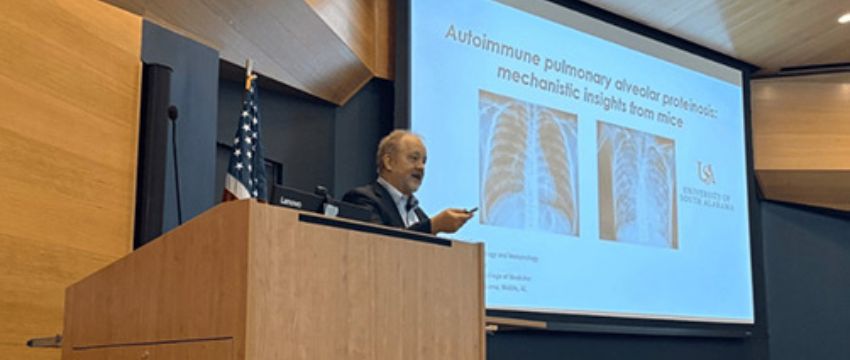 Dr. Barrington at podium giving a seminar.