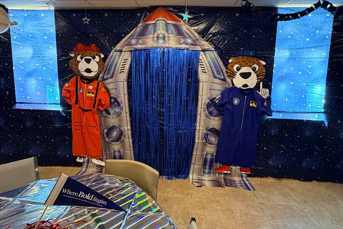 Room decorated for Homecoming with Southpaw and Ms Pawla dressed as astronauts with spaceship in between them.